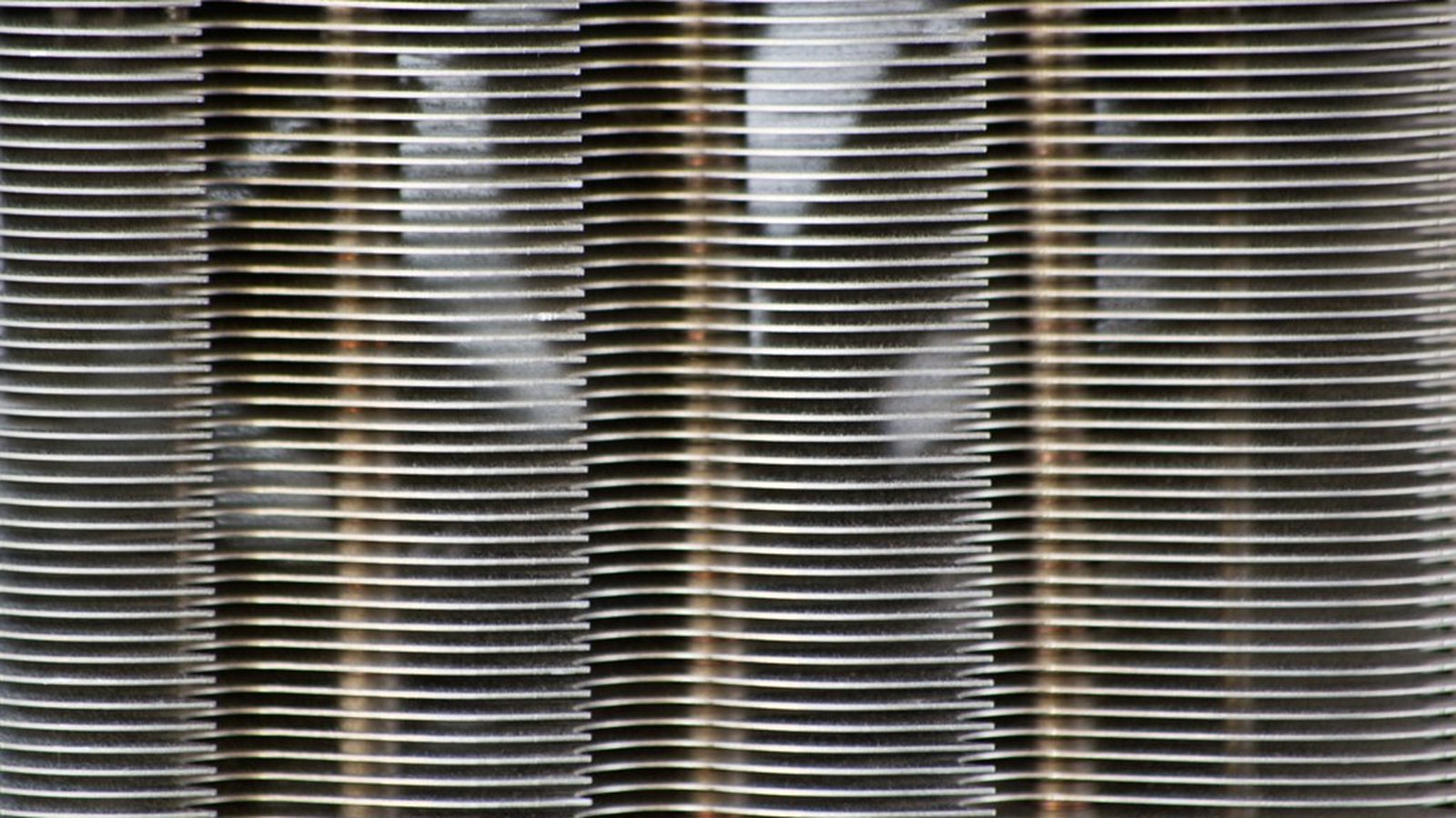 An extreme close-up of aluminum CPU heatsink fins, tightly stacked in vertical rows