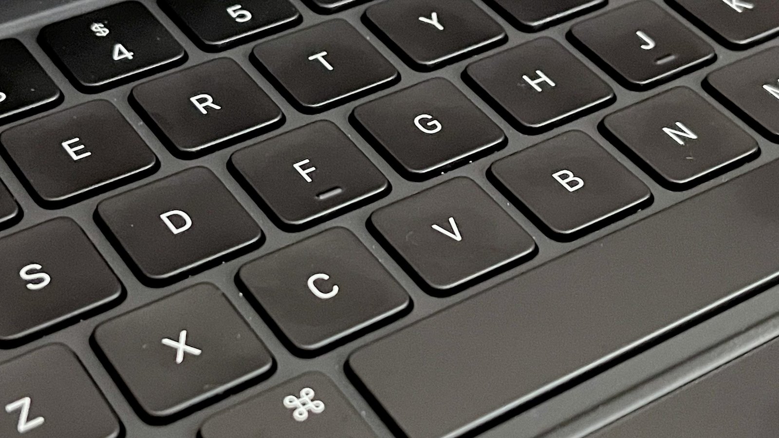 A close-up of a black keyboard's keys, angled to show the texture of the keycaps