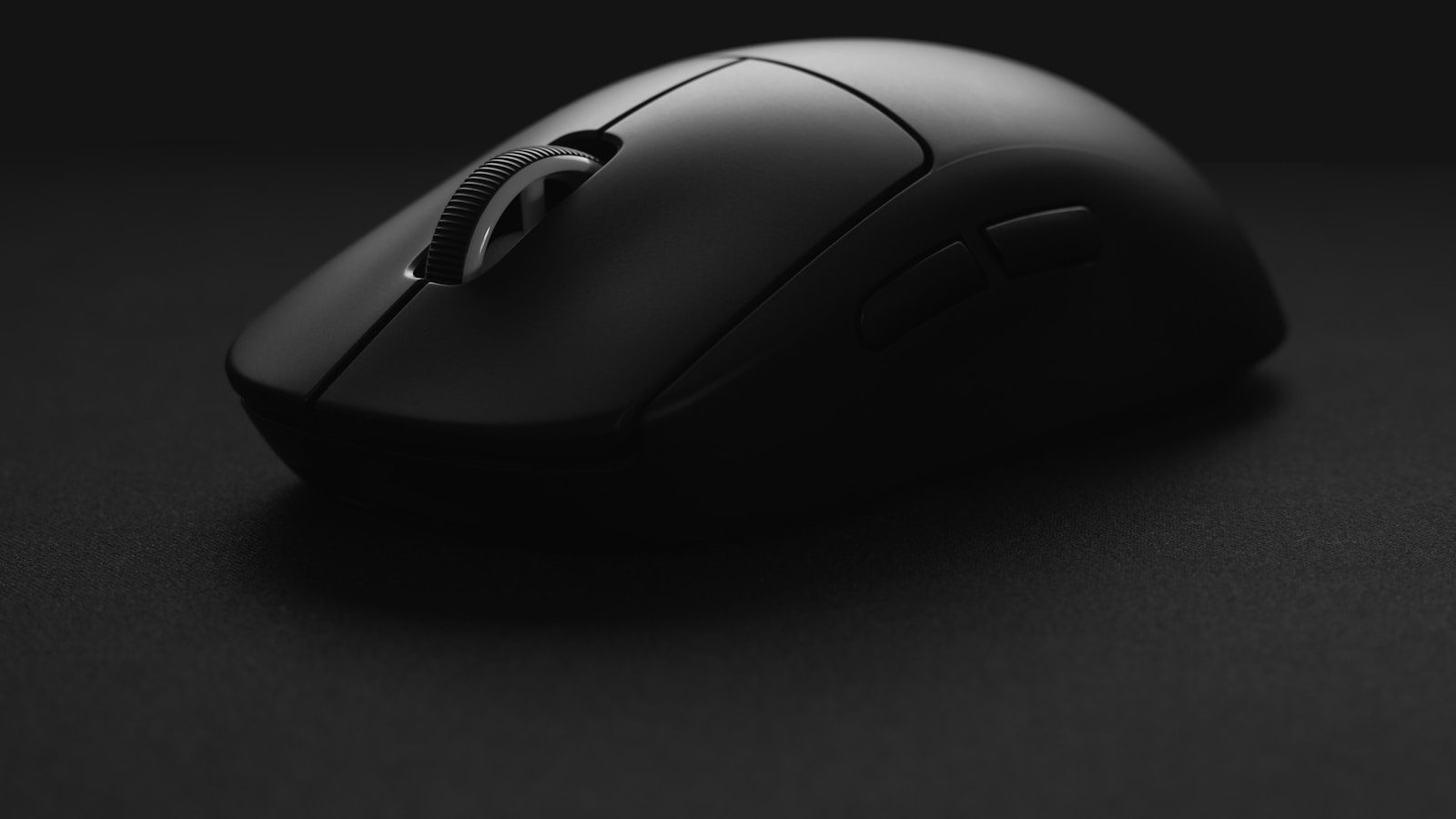 A dark wireless gaming mouse photographed close-up against a black background